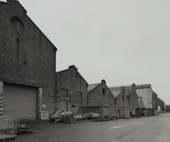 View from WSW along S side of former plumbers' shops with former engine works beyond.