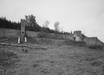 View from S within former walled garden, showing the remains of the walls, including two of its three towers