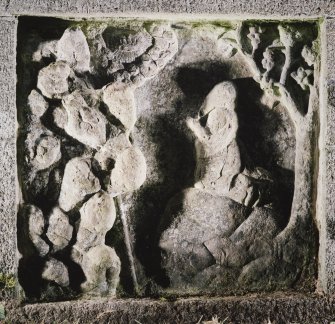 Detail of carved panel on left of well head depicting Moses praying and tetragrammaton