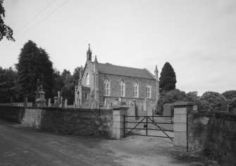 General view from SE showing church, churchyard and walls.