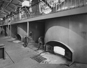 Interior.
Still House: view from W at lower level showing group of stills with welded steel cladding around fireboxes.