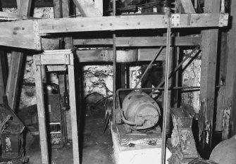 View of electric motor, probably installed to replace water wheel, powering machinery via a belt-pulley and line-shafts.