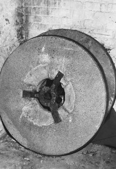 Detail of pair of millstones, removed and leaning against wall.