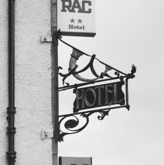 Wrought iron projecting hotel sign with post horn, detail