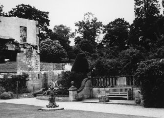 View from SE of NW corner of croquet lawn with sundial and part of the Queen Anne wing visible in background, showing renovation work after the fire.