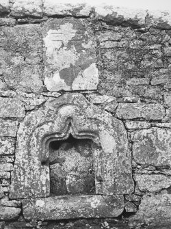 General view of grave-slab and piscina built into North-West wall, North-East of gate.