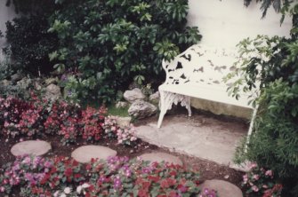 Detail of conservatory flower display and ornamental seat.