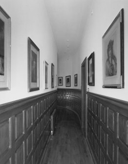 Interior. Ground floor view of framed engraving lined corridor in East wingcorridor