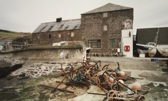 General view from S (harbour side), showing former granary (right) and fish-processing bays (left), which were added in 1896