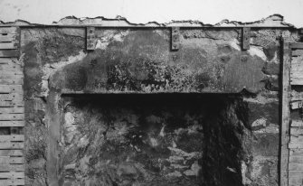 Detail of lintel (reused stair tread) over fireplace in central room in North range on first floor.