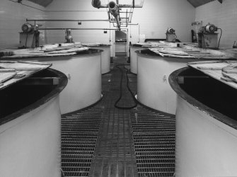 Interior.
View from SSW of Tun Room, showing 6 steel washbacks, with wooden covers.