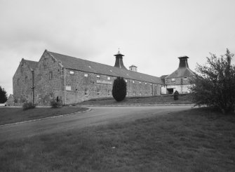 View of distillery from SW showing range of former Maltings floors, and two associated malt-drying Kilns.