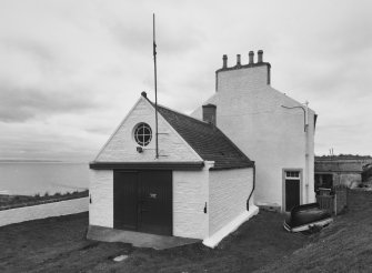 Detailed view from E of coastguard station, with houses behind