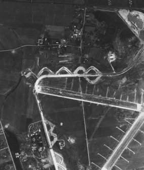 RAF WWII vertical aerial photograph of the NW part of Dallachy Airfield during the construction phase.  Visible are part of the main runways, the perimeter track and technical area.  Also visible is the small village of Nether Dallachy