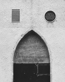 Detail of inscribed panel over door with information plaques above