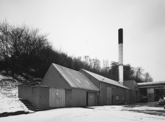 View from NE of range of buildings at S side of distillery, containing Engineers' Workshops, Boilerhouse and Yeast store.