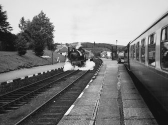 View of steam train and foot bridge from platform