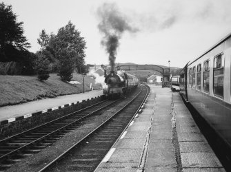 View of steam train and foot bridge from platform