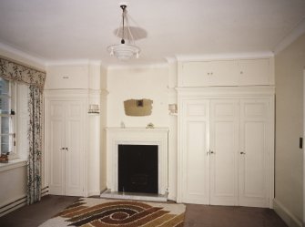 Interior. First floor View of 1922 extension S centre bedroom from E showing fireplace and fitted wardrobes