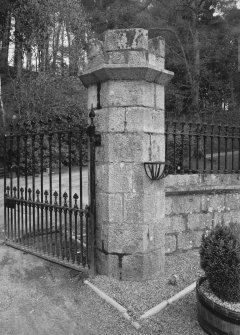 Crenellated gate pier, wrought iron gate, wall surmounted by railings, detail