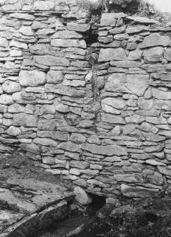 North wall of byre showing drainage channel and remains of cruck stump