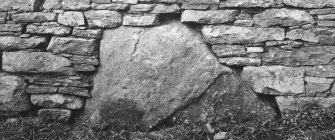 Dwelling range, east end.  Large boulder stone at base of wall.