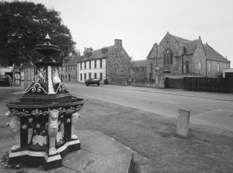 Ardesier Parish Church and 57 and 58 High Street. General view from NE showing late 19th century cast iron fountain