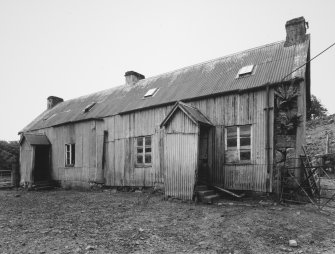 General View of former farm house from South showing tin sheeted roof and wall