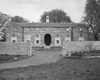 View of front of stable block and yard wall from West