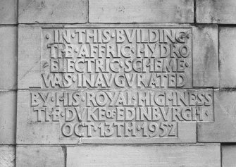 Detail of commemorative plaque to left of main entrance on W facade