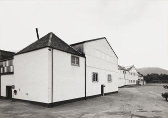 View from N along NW frontage of main block, showing still House in foreground.