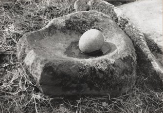 Turning stone in basin at foot of early Christian cross.