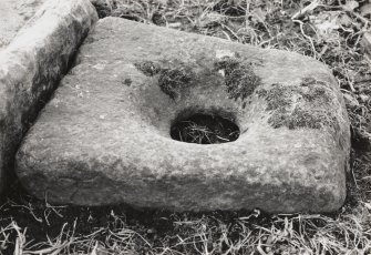 Rectangular holed stone at foot of early Christian cross.