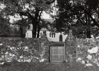 General view from E showing entrance gate and church beyond