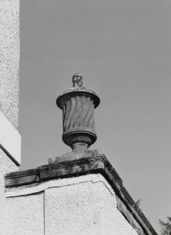 Detail of lidded urn on corner of flat-roofed wings