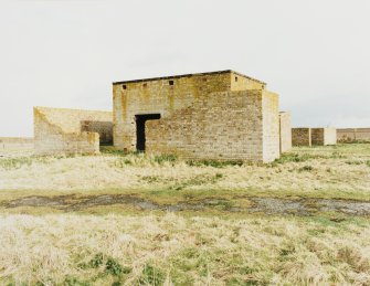 Fearn Airfield, Loans of Tullich accommodation camp.  View from NW of main engine-house for electricity generation with blast walls still in situ.   Emergency generator and perimeter fence are visible to the rear.