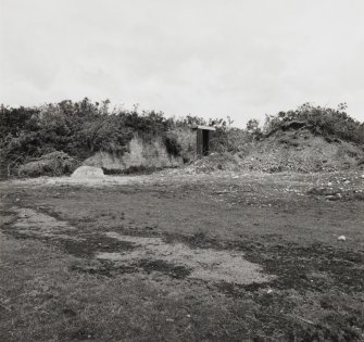 Fearn Airfield bomb store on N side of airfield.  Showing the remains of protective earthworks with brick built bomb store building visible in centre.