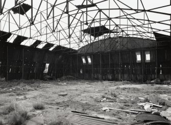 Fearn Airfield, W dispersal/perimeter area.  Interior view of Mainhill type hangar from NE showing steel roof framing and sloping rear and side walls.