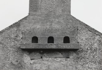 Loans of Tullich, (Fearn Airfield accommodation camp).  Detail of gable on 19th century steading showing small dovecot built into the wall head.  The dovecot or nesting box with three entrances is dated 1889.
