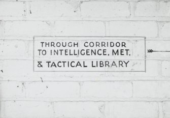 Tain Airfield Operation Block, detail of sign painted on wall 'Through corridor to Intelligence, Met. & Tactical Library'.