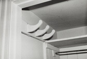 Interior-detail of wooden cloak pegs in cupboard adjacent to end apartment on First Floor of North West wing