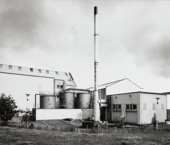 View of oil tanks and chimney from South