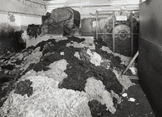 Teazing Department (building 42): view of larger of two teazing machine, with dyed wool (foreground) ready to be loaded [the building numbers in brackets refer to the itemised plan, D33088]