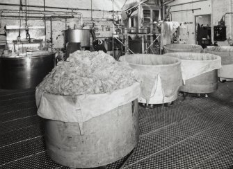 Dye House (building 8/9): view of tubs containing recently dyed yarn, emptied from dye-pod (in background to left).  A piece-dyeing machine can also be seen (background right) [the building numbers in brackets refer to the itemised plan, D33088]