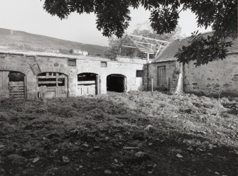View of courtyard with cattle shelters from S