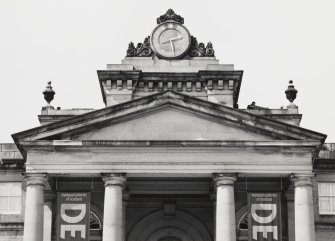 View of pediment of portico with clock tower above from south