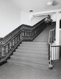 Interior, view of staircase at ground floor level with tiled dado