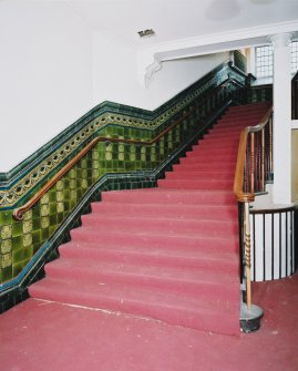 Interior, view of staircase at ground floor level with tiled dado