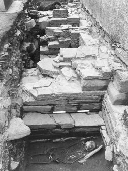 Excavation trench along base of church wall. Skeleton in situ.