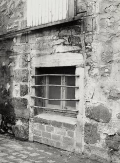 Detail of remains of semi-blocked up doorway with bars across window